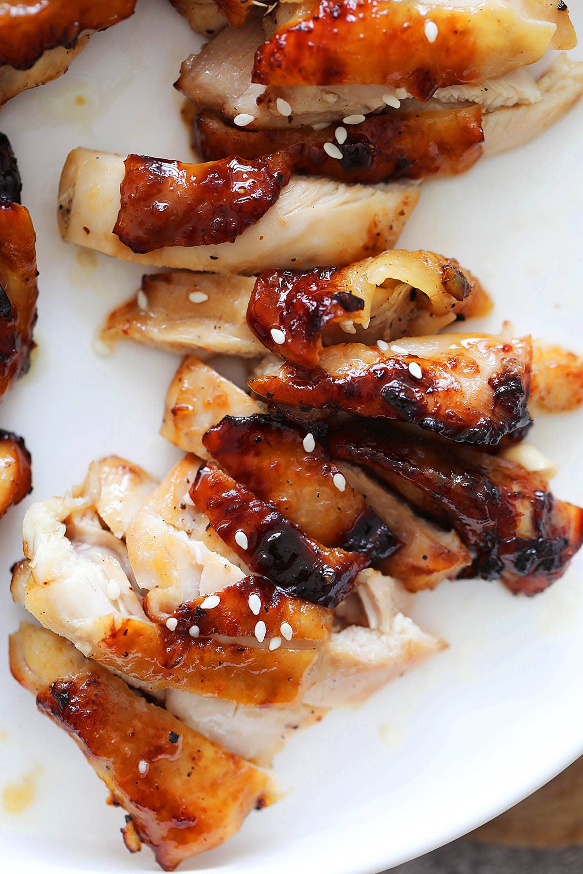 Sliced honey glazed air fryer chicken thighs served on a plate.