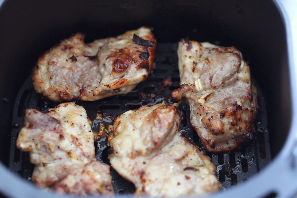 Honey garlic chicken thighs in the air fryer basket.
