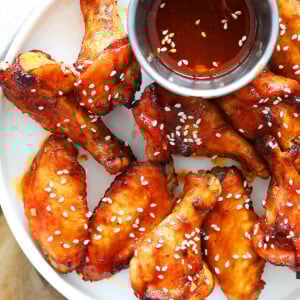 Air fryer Korean chicken wings served on a plate with a side of dripping.