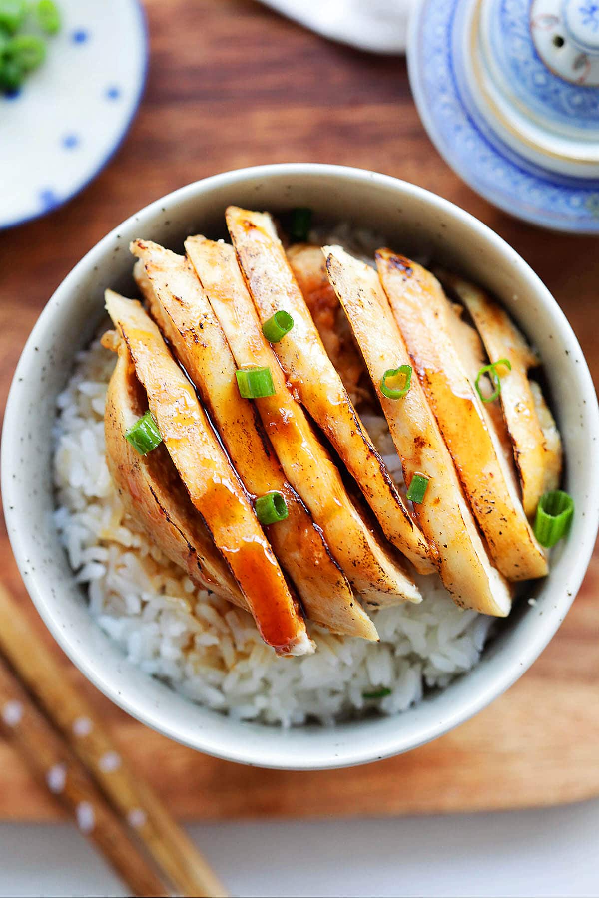 Juicy chicken in a tangy Mandarin sauce, garnished with scallions and served with rice.