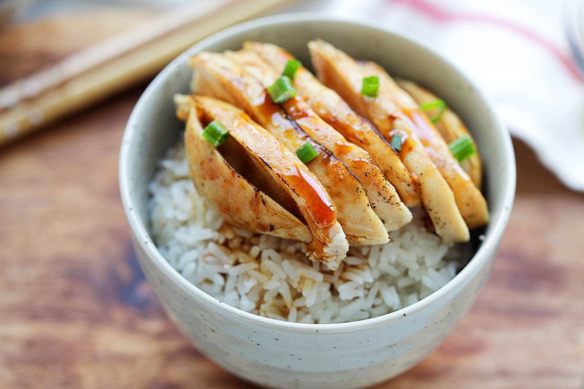 Healthy Mandarin chicken with a flavorful sauce, served with steamed rice and fresh scallions.