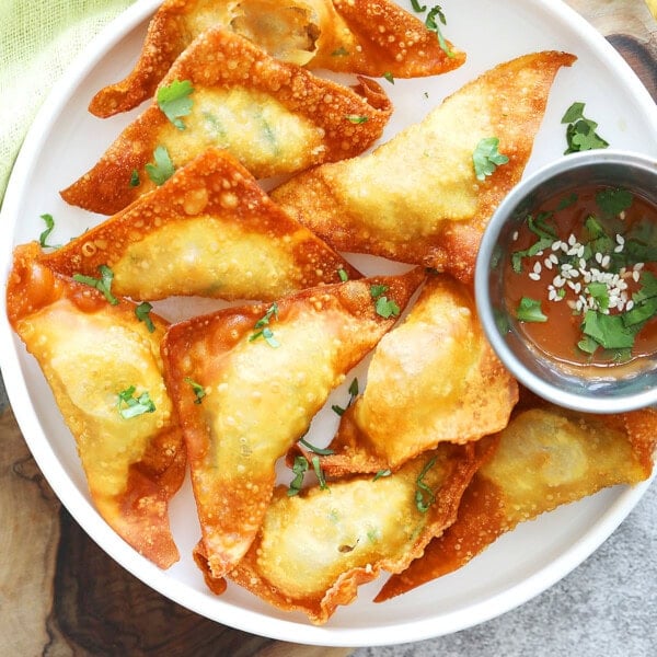 Thai fried wontons served with a small bowl of sweet chili dipping sauce.