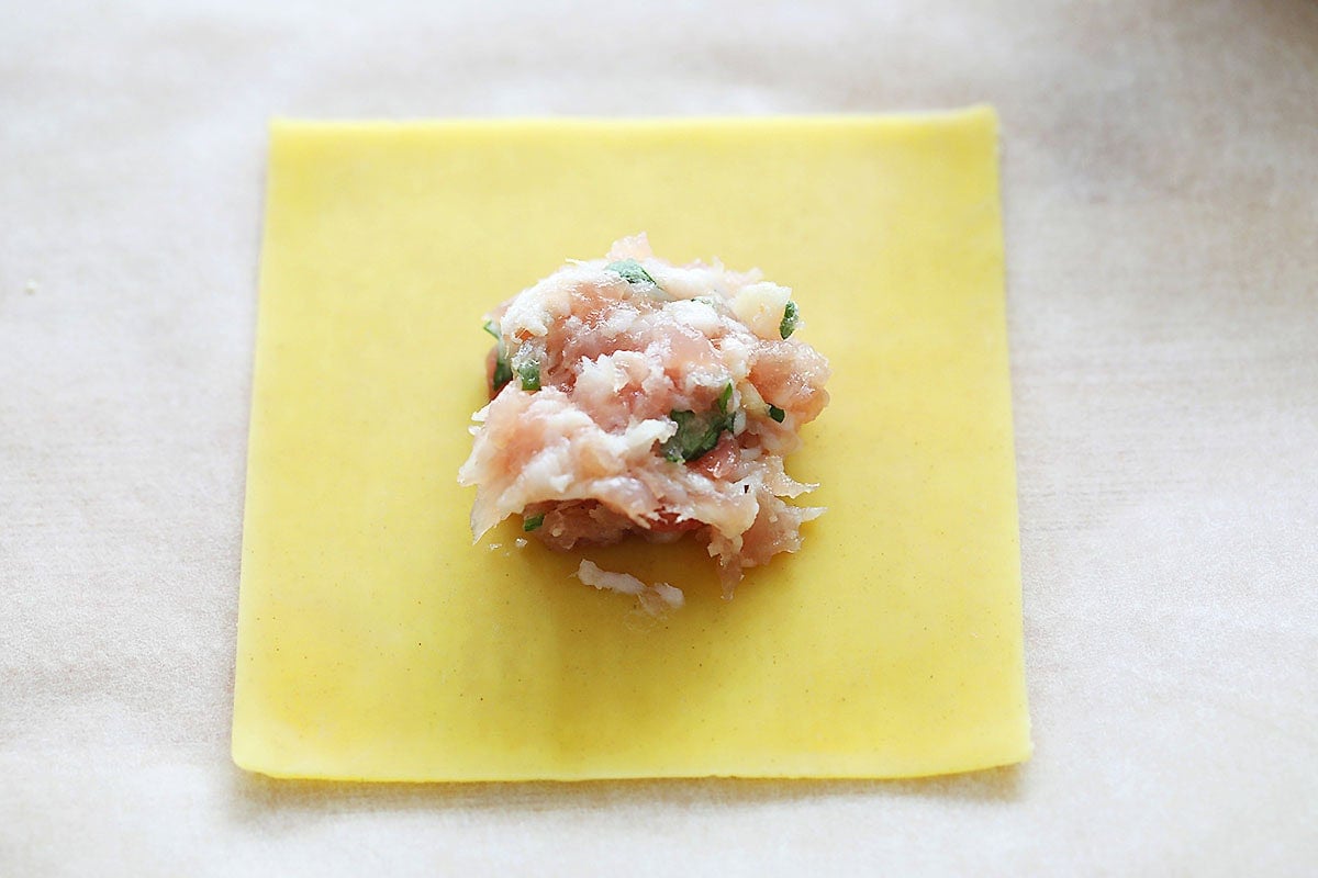 Pork filling in the center of a wonton wrapper.