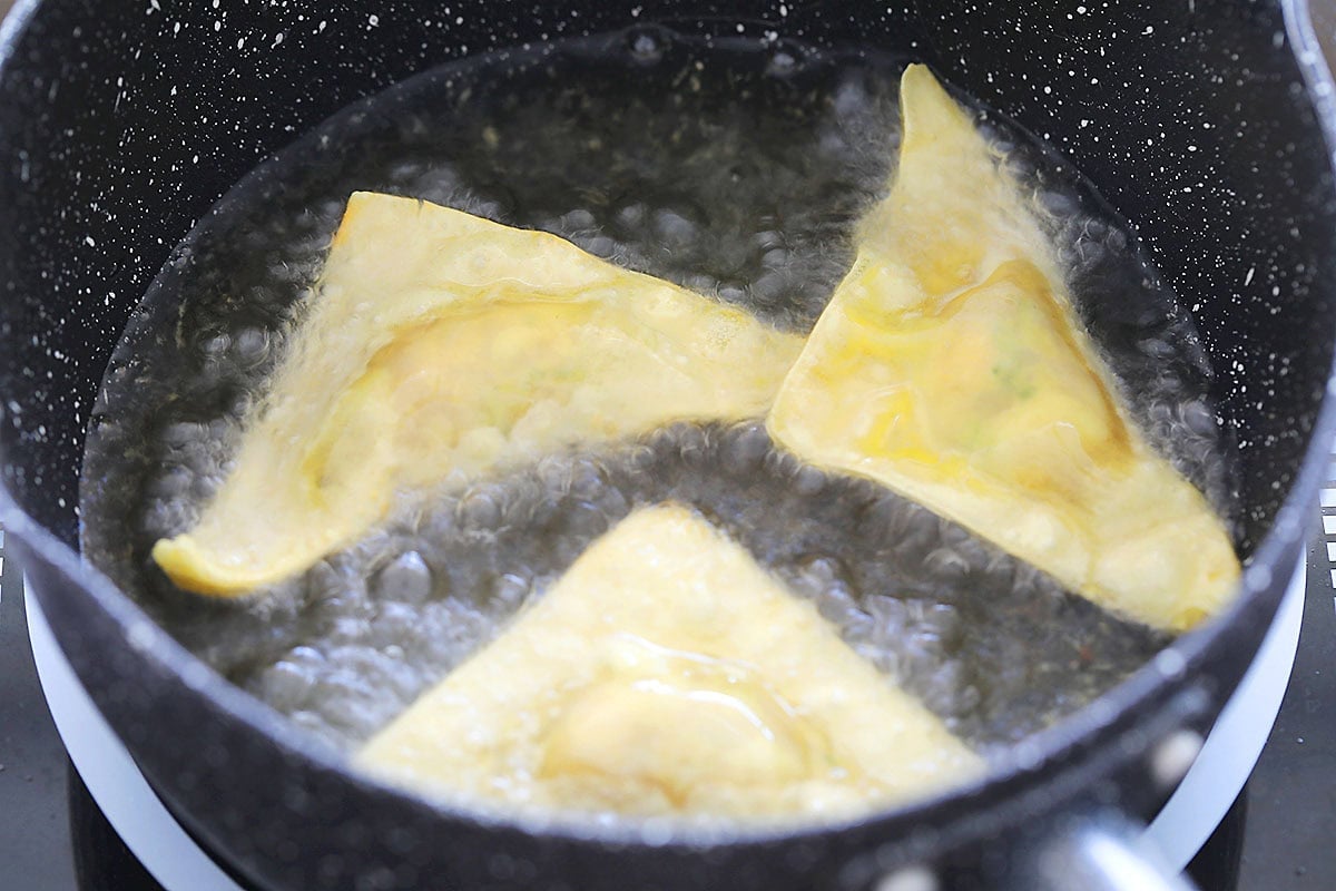 Thai wontons frying in hot oil.