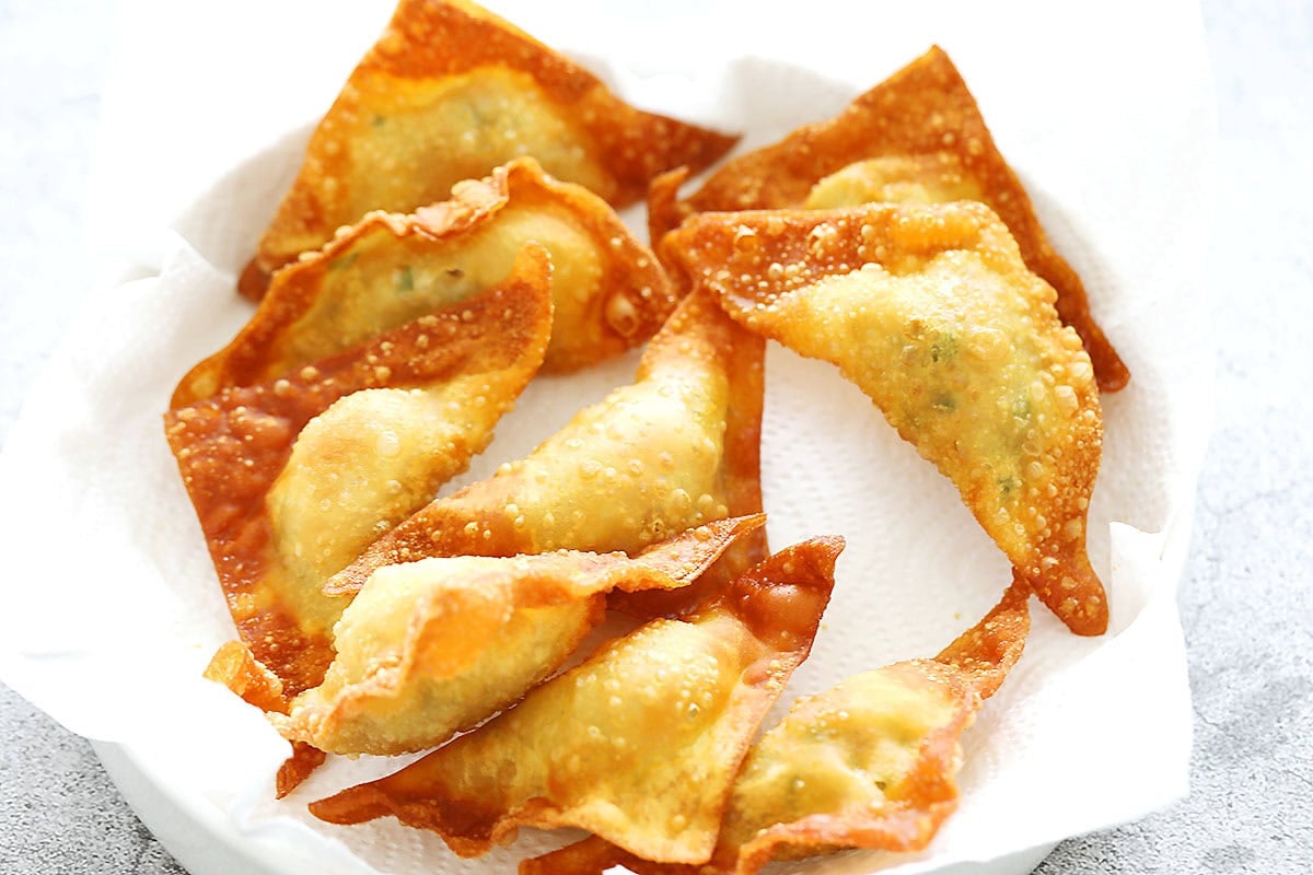 Crispy Thai pork fried wontons on a paper towel-lined plate.