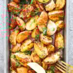 Golden air fryer baby potatoes with Parmesan crust and fresh parsley garnish.