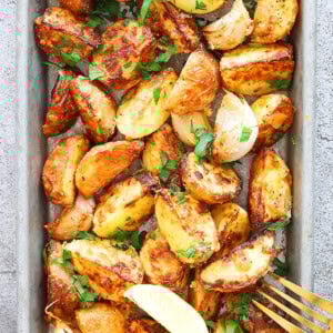 Golden air fryer baby potatoes with Parmesan crust and fresh parsley garnish.