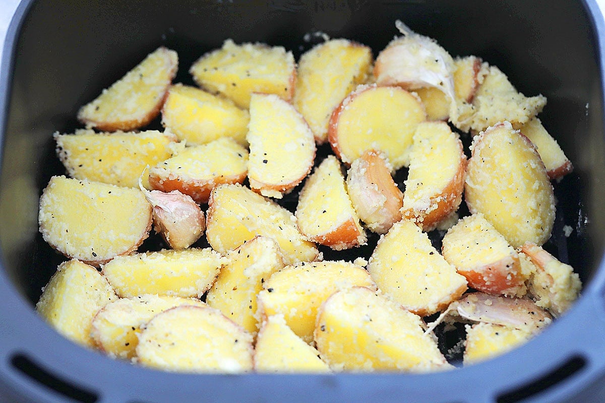Baby potatoes arranged skin-side down in air fryer basket.