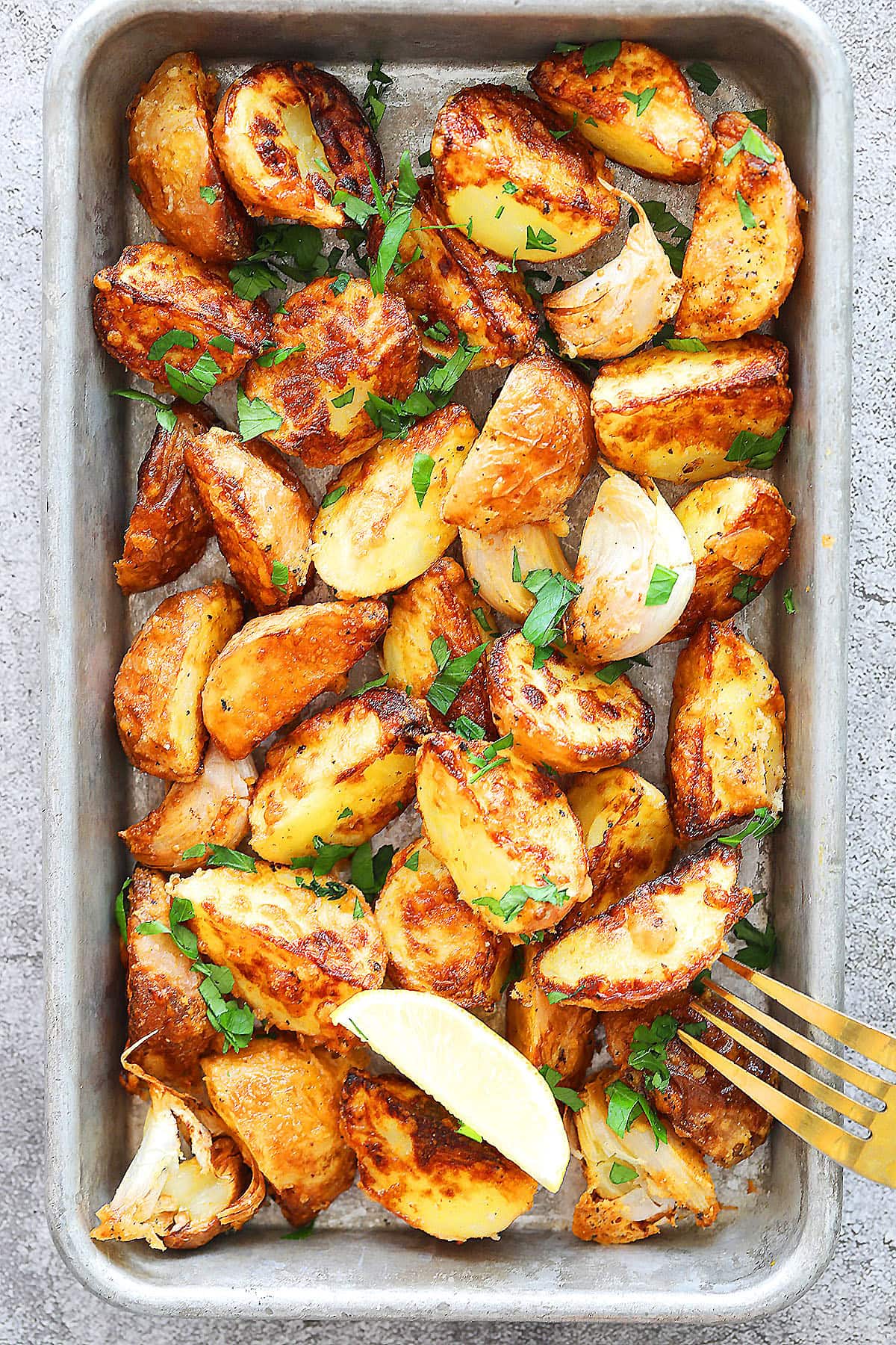 Golden air fryer baby potatoes with Parmesan crust and fresh parsley garnish.