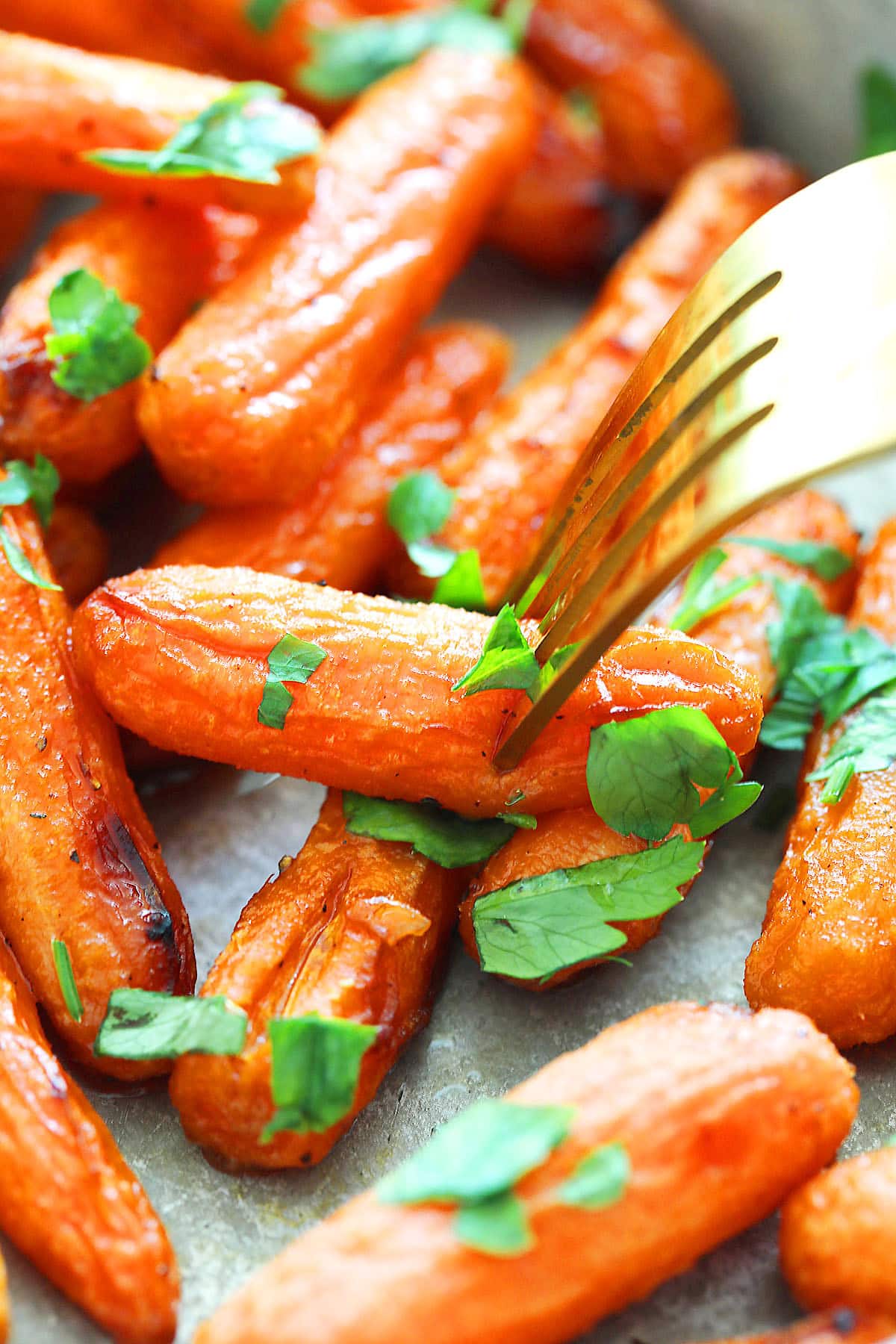 Air fryer honey butter carrots pierced with a fork.