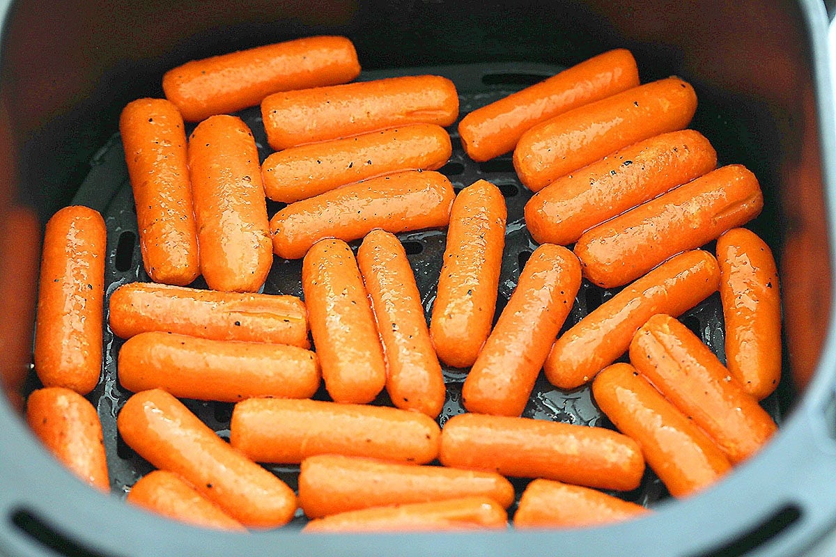 Honey butter baby carrots arranged in the air fryer basket.