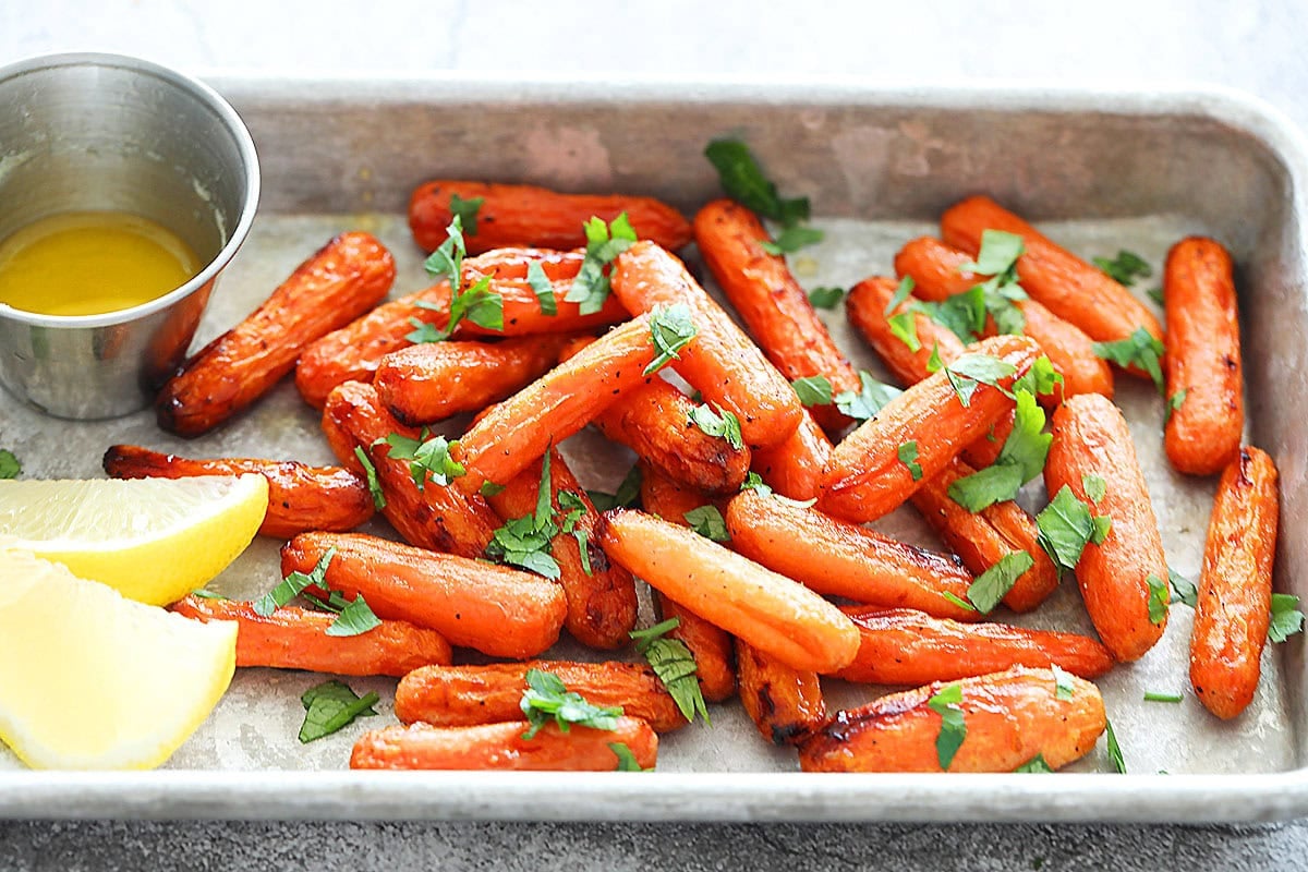Air fryer honey butter carrots served on a tray with pan drippings.