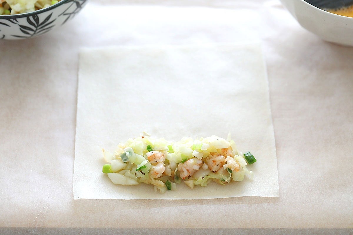 Spring roll wrapper with filling placed near edge.