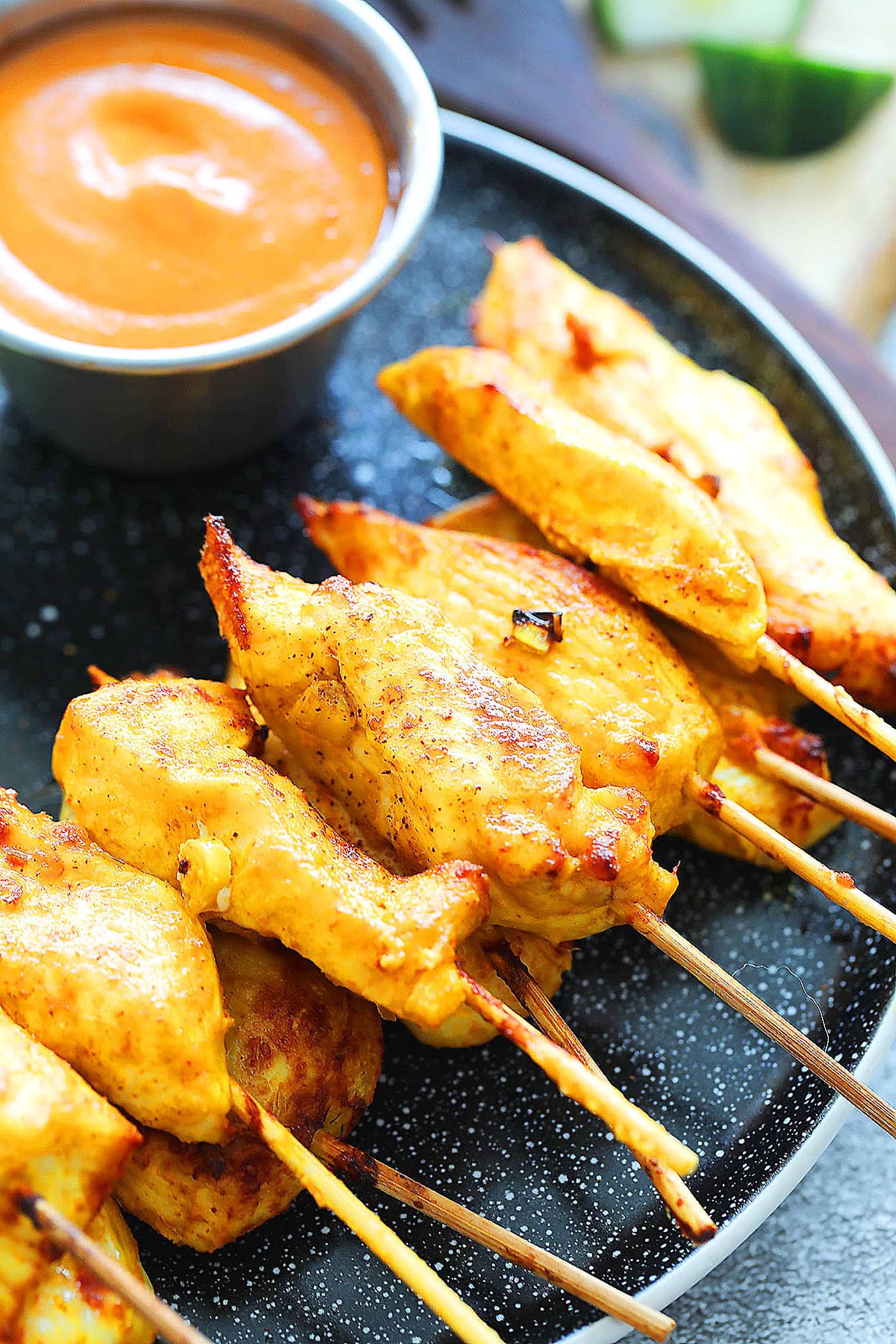 Air fryer Thai chicken satay plated with a side of creamy peanut dipping sauce.