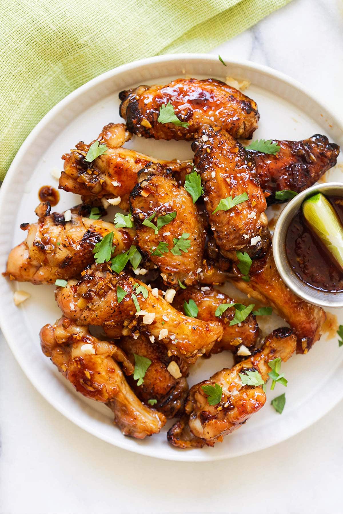 Vietnamese chicken wings on a plate, topped with peanuts and cilantro.