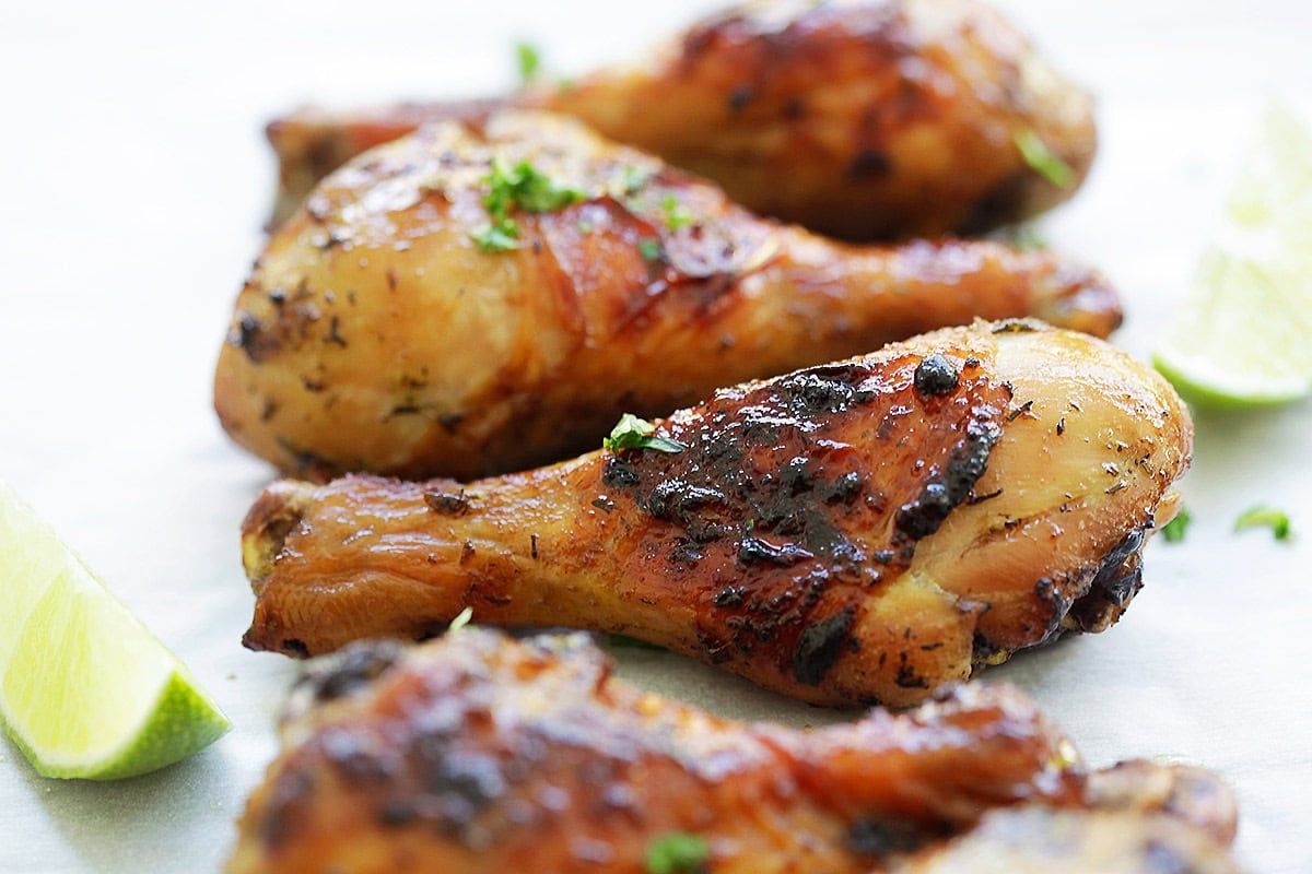 Grilled Jamaican jerk chicken with golden, charred skin, garnished with parsley.