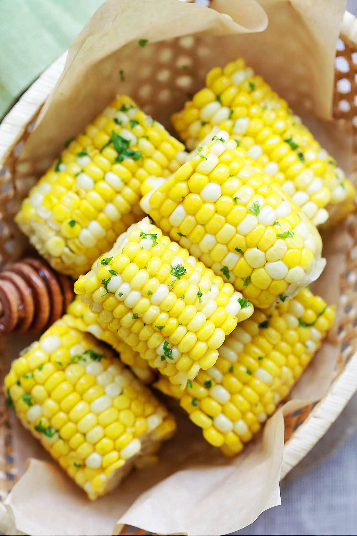 Easy honey butter corn on the cob arranged in a wooden basket.