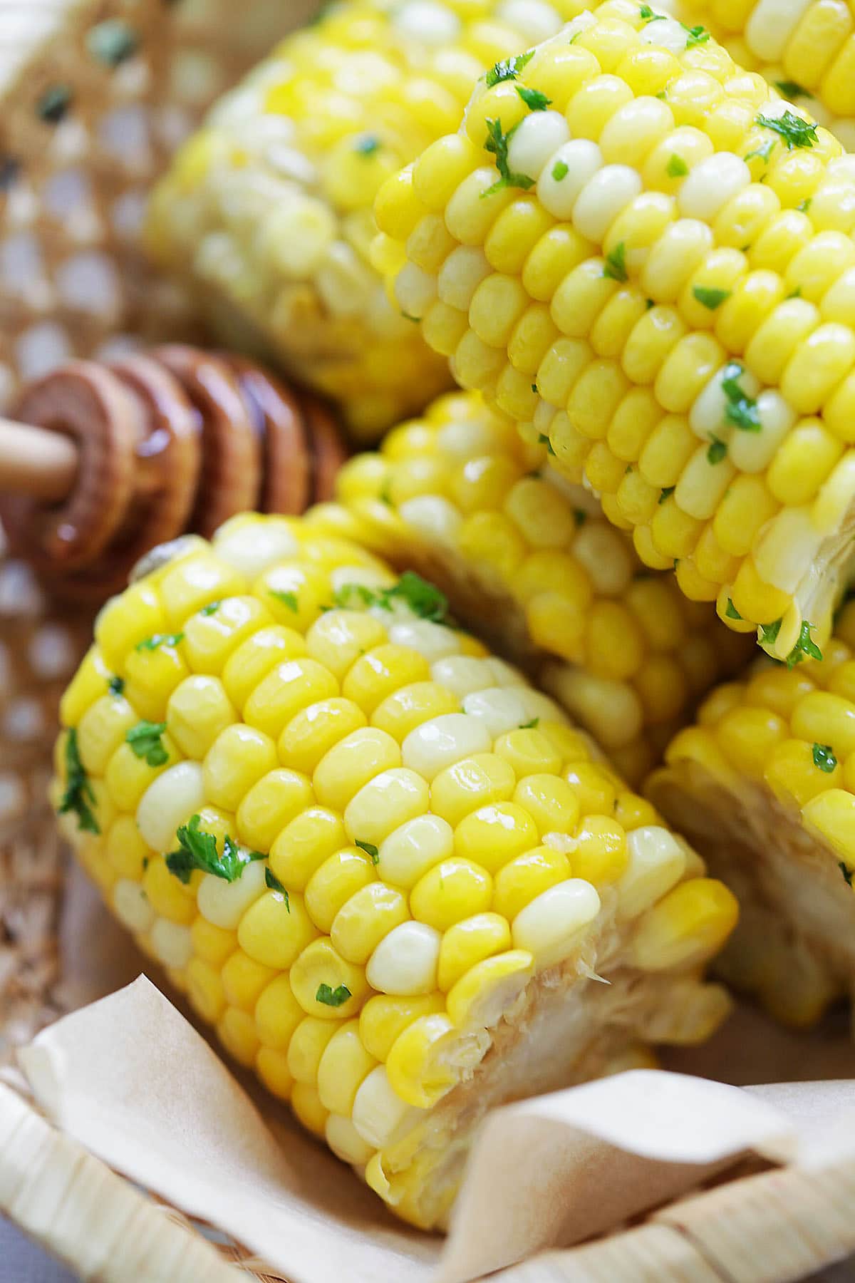 Juicy honey butter corn glistening with butter and honey in a wooden basket.