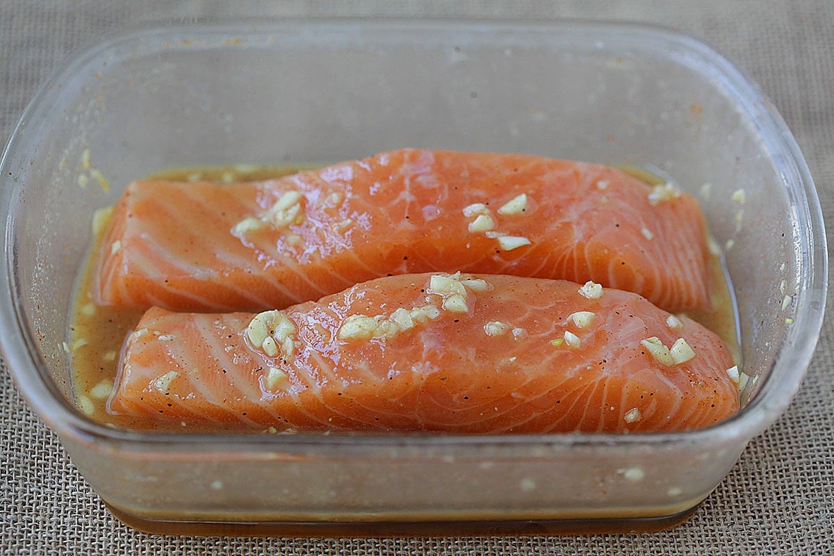 Salmon fillets with honey mustard sauce in a container.
