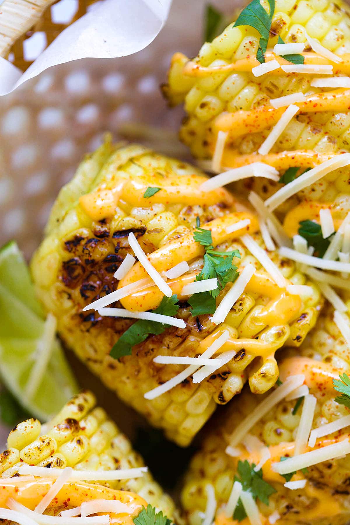 Easy grilled corn on the cob loaded with spicy mayo, shredded Parmesan, and chopped cilantro.