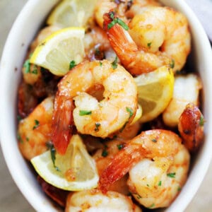 Garlic herb oven baked shrimp served with lemon wedges.