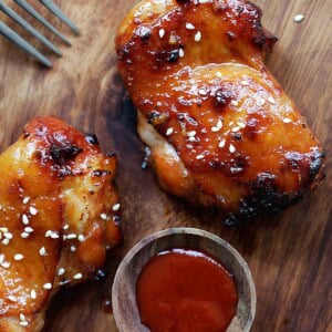 Sticky and sweet Sriracha chicken served with a side of Sriracha sauce.