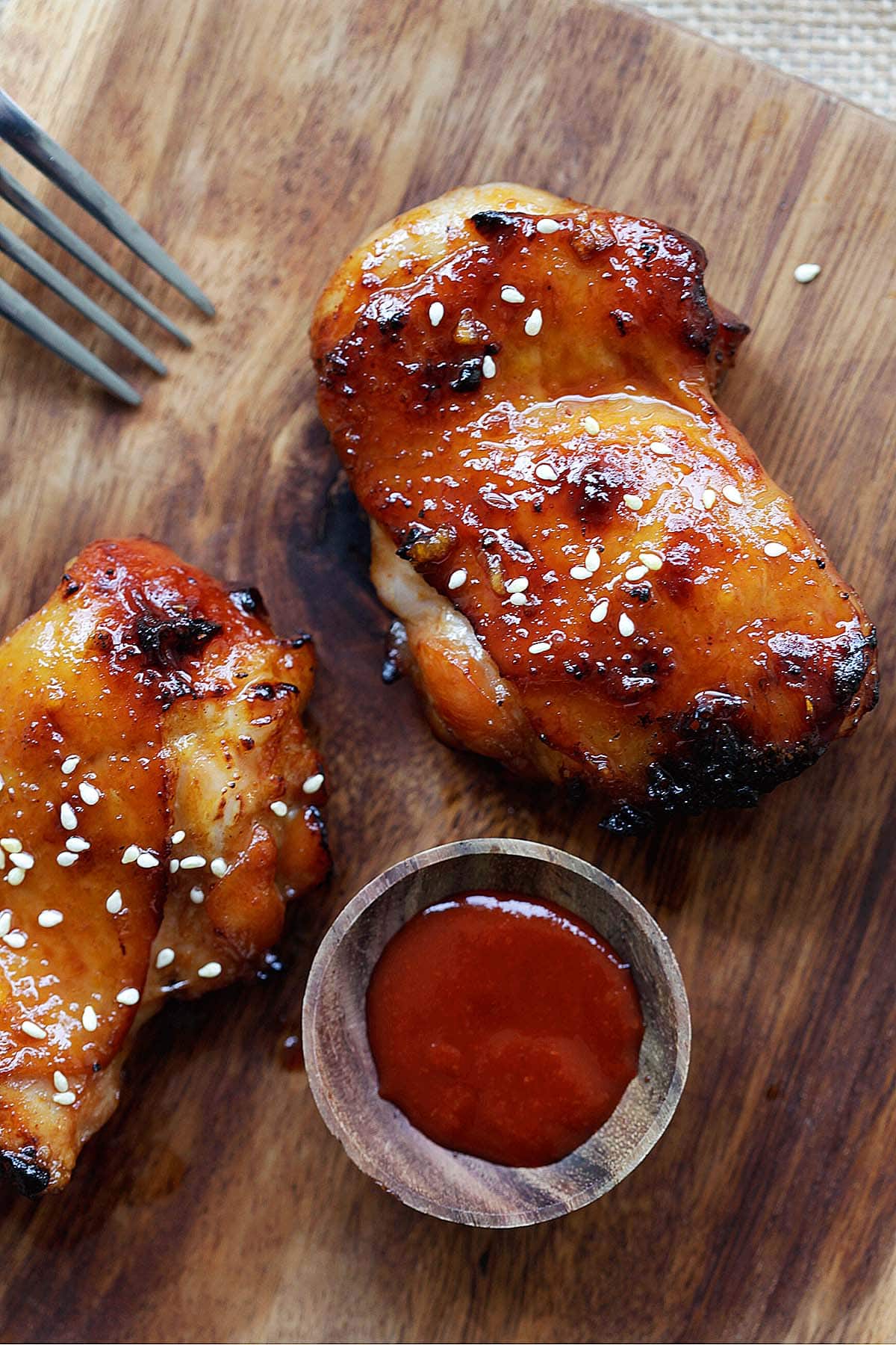Sticky and sweet Sriracha chicken served with a side of Sriracha sauce.