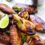 Sweet chili chicken wings served with Thai sweet chili sauce and fresh lime wedges.
