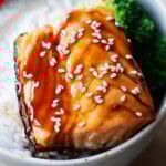 Teriyaki salmon served over rice with broccoli florets.