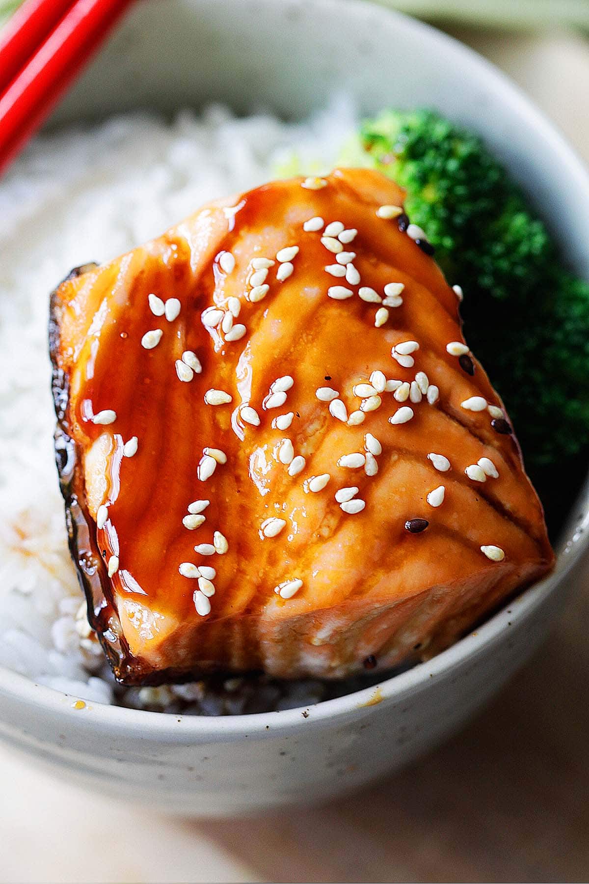 Teriyaki salmon served over rice with broccoli florets.