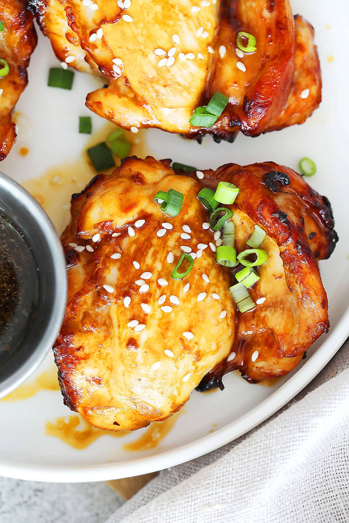 Glossy air fryer teriyaki chicken made with boneless chicken thighs on a serving plate.