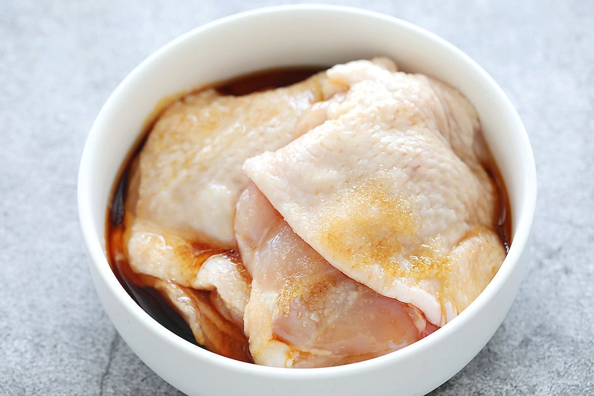 Boneless chicken thighs with homemade teriyaki sauce in a bowl.
