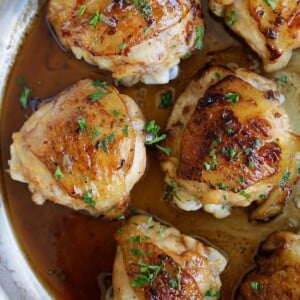 Golden brown balsamic and honey chicken thighs glazed with sauce in a skillet.