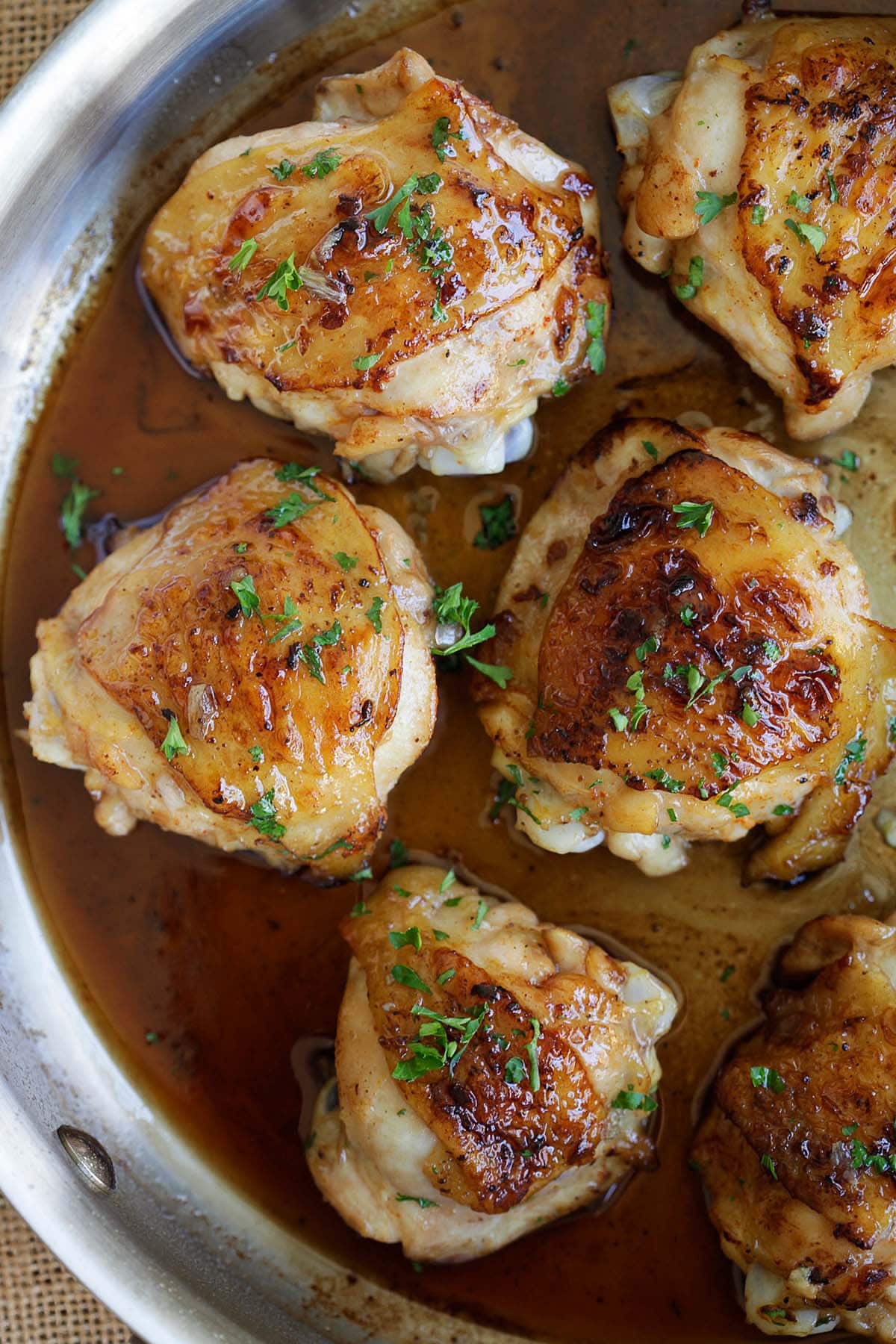 Golden brown balsamic and honey chicken thighs glazed with sauce in a skillet.