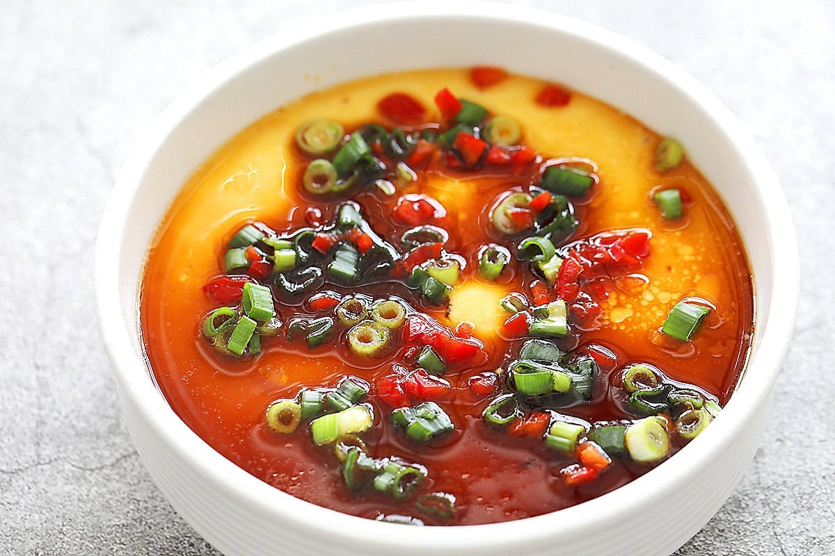 Smooth and tender Chinese steamed eggs in a shallow bowl, ready to serve.