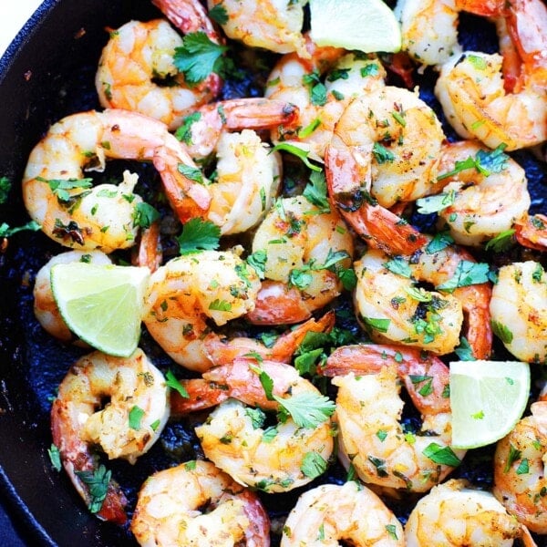 Cilantro lime shrimp recipe cooked in a cast-iron skillet with garlic, butter, and fresh lime.