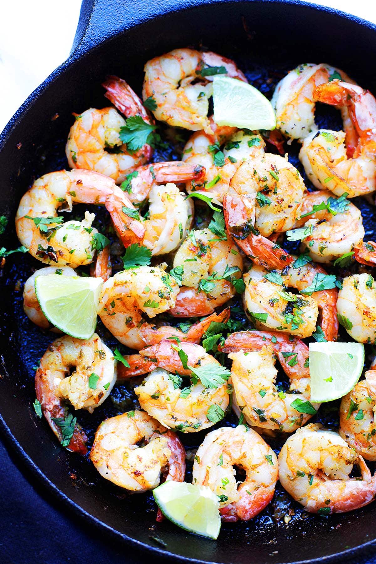 Cilantro lime shrimp recipe cooked in a cast-iron skillet with garlic, butter, and fresh lime.