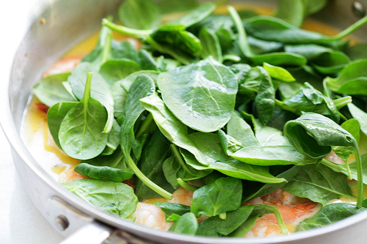 Spinach and shrimp in a skillet.