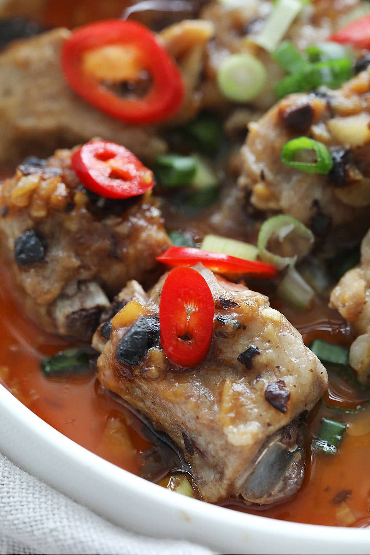 Chinese steamed pork ribs topped with scallions and red chilies.