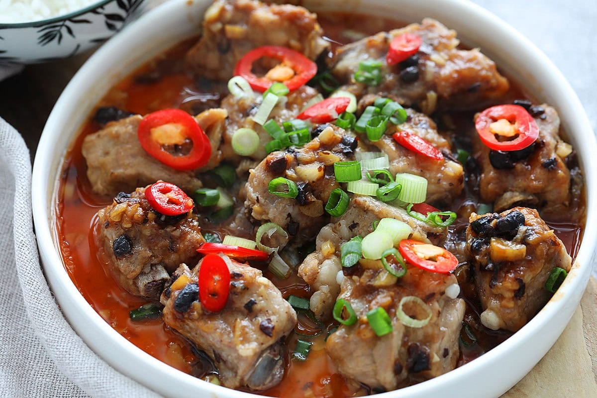 Chinese steamed pork ribs with black bean sauce served with a bowl of rice.