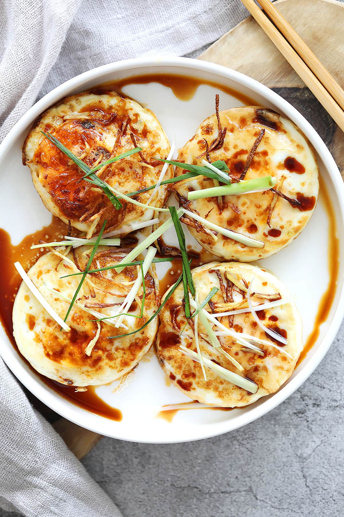Ginger soy eggs topped with crispy ginger strips and scallions.
