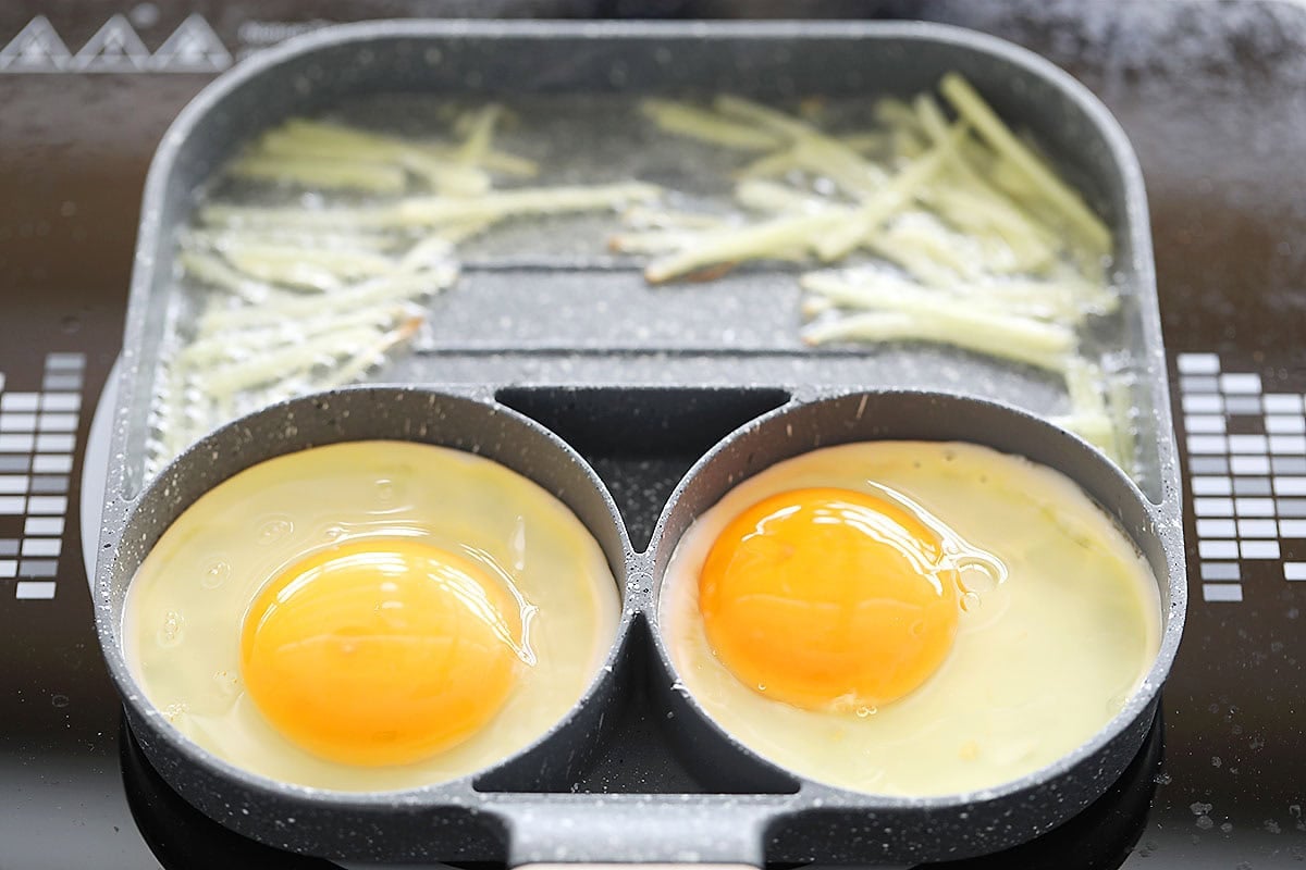 Eggs and ginger strips in a hybrid pan.