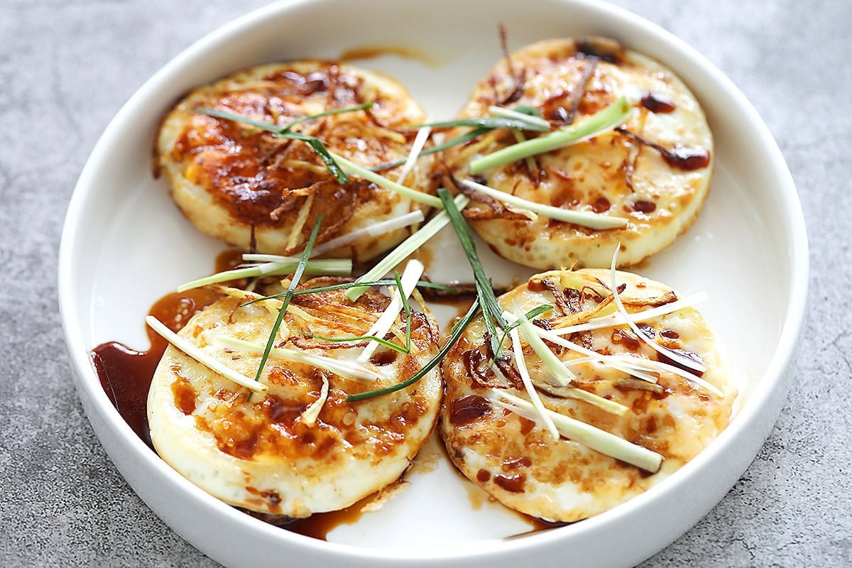 Easy ginger soy egg recipe topped with crispy ginger strips and fresh scallions.