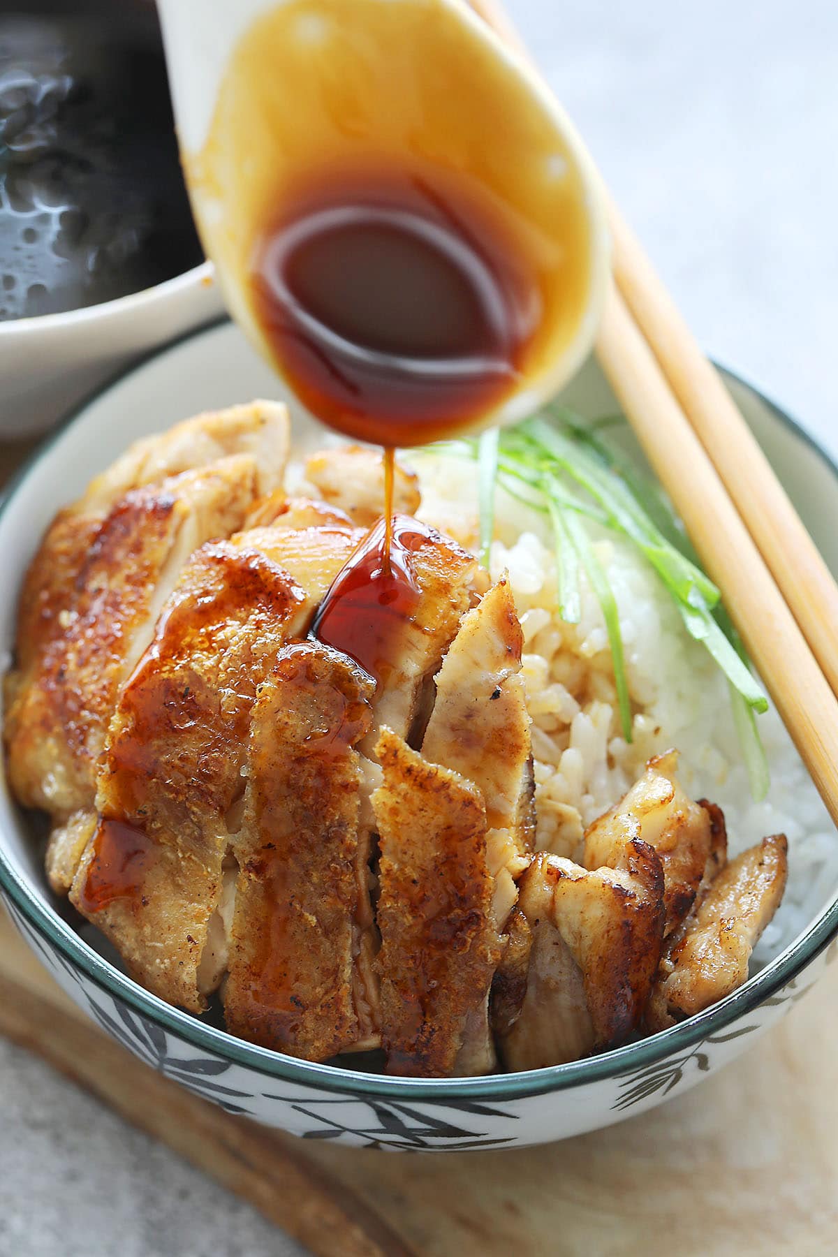 Teriyaki sauce being drizzled over chicken.