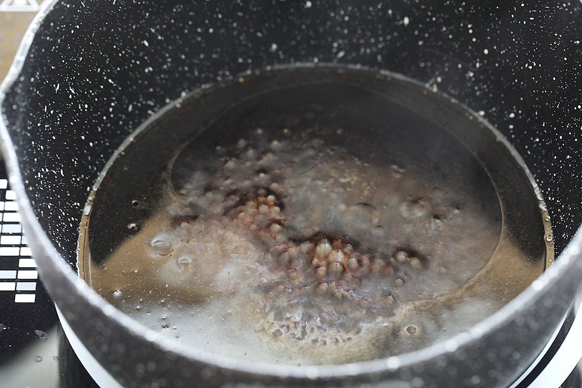 Steamed fish sauce boiling in a saucepan.