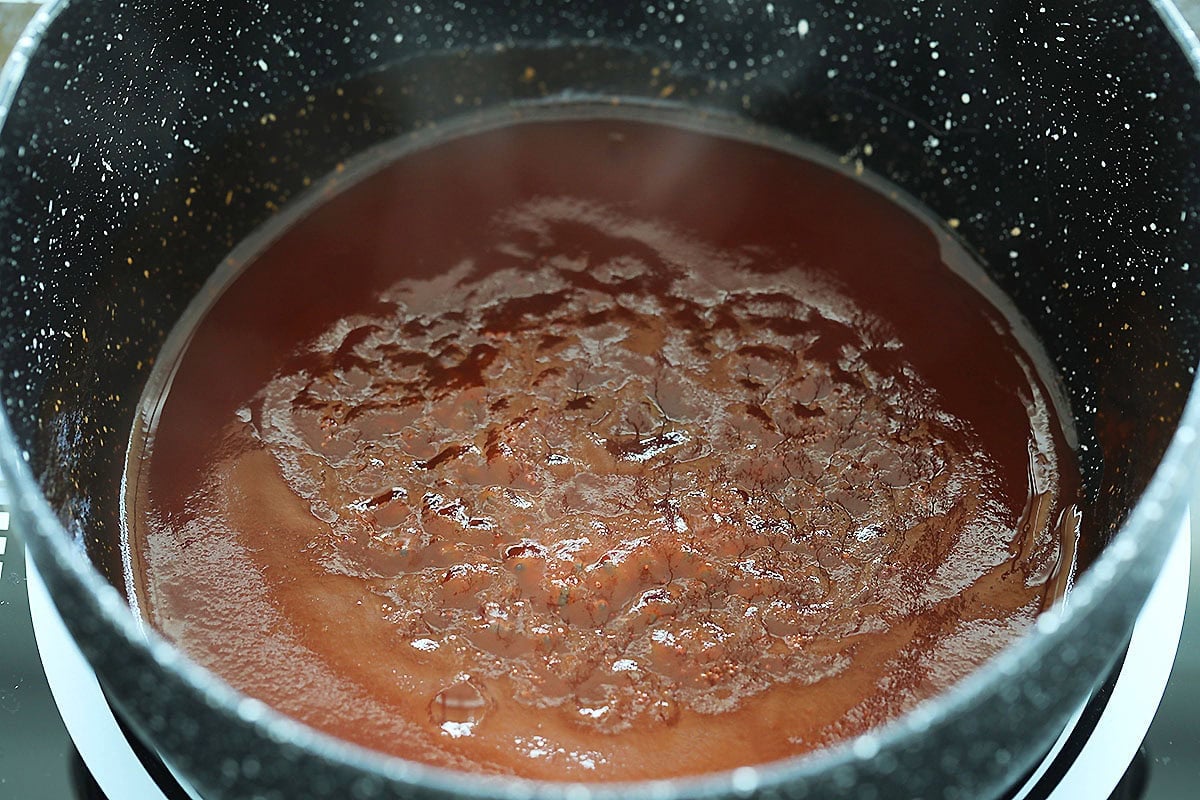Homemade sweet and sour sauce bubbling gently in the saucepan.