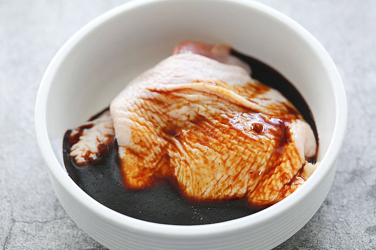 Chicken thighs and char siu sauce in a bowl.