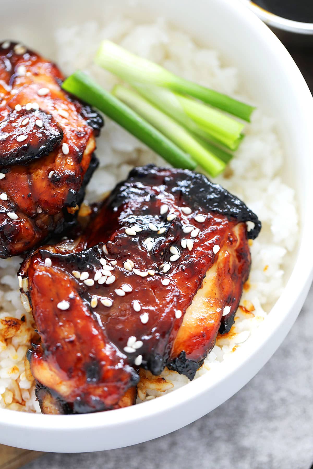 Juicy Chinese BBQ chicken cooked in the air fryer and served over a bowl of steamed rice.