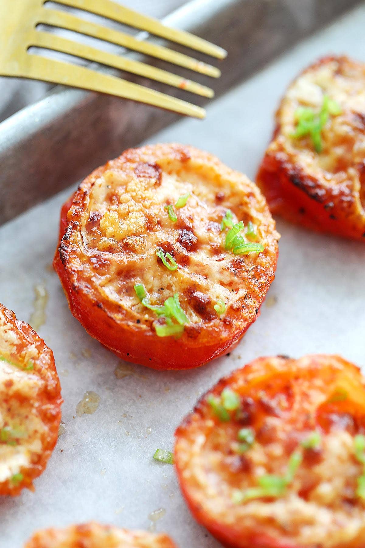 Air fryer roasted tomatoes topped with Parmesan cheese.