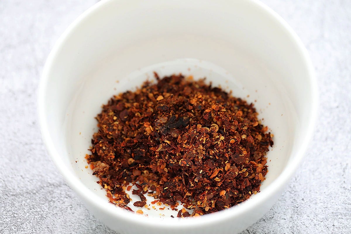 Dried red pepper flakes and cloves in a bowl.